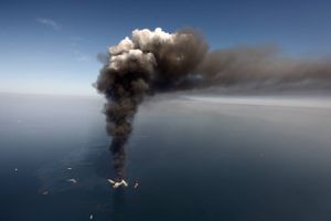 FILE - In this April 2010 file photo, oil can be seen in the Gulf of Mexico, more than 50 miles southeast of Venice on Louisiana's tip, as a large plume of smoke rises from fires on BP's Deepwater Horizon offshore oil rig. Deep-water drilling is set to resume near the site of the catastrophic BP PLC well blowout that killed 11 workers and caused the nation's largest offshore oil spill five years ago off the coast of Louisiana. (AP Photo/Gerald Herbert, File)