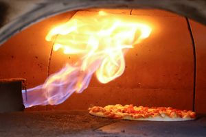 I en restaurant i Bonn er en pizza er ved at blive bagt i en traditionel italiensk pizzaovn, der fyres med naturgas. Foto: Reuters/Wolfgang Rattay