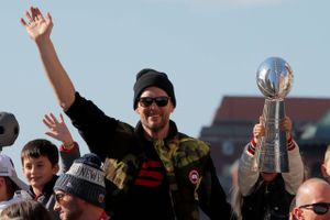     FILE PHOTO: New England Patriots quarterback Tom Brady waves as his daughter Vivian holds up a Lombardi trophy during a victory parade after winning Super Bowl LIII, in Boston, Massachusetts, U.S., February 5, 2019. Arkivfoto: Brian Snyder/Reuters