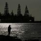 Som symboler på oliepriskrigen og coronakrisen ligger store offshore-borerigge uvirksomme hen i Den Mexicanske Golf ud for Port Aransas i Texas. Foto: AP/Eric Gay