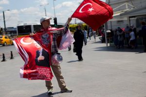 En gadesælger i Istanbul forsøger at lokke kunder til flag, der kan benyttes ved demonstrationer til fordel for præsident Erdogan. Foto: Petros Giannakouris/AP