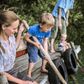 Einar på snart fem år, Albert på et år og Mathilde og Simon Foldschack bor i et stort kollektiv ude på landet. Her har de både en kæmpe have, deres egen sø og en lille skov, hvor børnene kan lege. »Man skal være parat til at vælge bylivet fra,« siger Mathilde Rosendahl Foldschack. Foto: Cecile Smetana.
