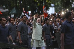 Premierminister Narendra Modi vinker til de fremmødte, da han ankommer til sit partihovedkvarter i New Dehli efter sin store sejr i søndagens delstatsvalg. Foto: AP