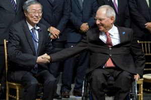 På trods af de magre vækstudsigter smiler Kinas centralbankpræsident Zhou Xiaochuan (t.v.), da han hilser på Tysklands finansminister Wolfgang Schäuble.