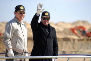 Den vinkende mand er Egyptens præsident Abdel-Fattah el-Sisi, og det er på hans ordre, at Suez-kanalen nu er blevet udvidet på et år i stedet for tre. Hensigten er, at det skal skubbe landets trængte økonomi i gang.