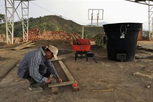 En bygningsarbejder er i gang med at reparere fodboldbanen i Esperanza, en landsby nær Buenos Aires, Colombia. Foto: Joshua Partlow/Washington Post