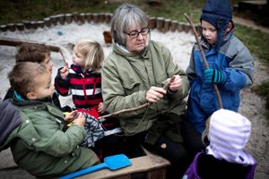 »Jeg er glad for, at jeg ikke er nyuddannet pædagog,« siger Dorthe Karlog om de færre ressourcer, som kræver mere af den enkelte pædagog. På legepladsen er hun omgivet af (fra venstre mod højre) Theodor, Emil, Frida og Marck. Foto: Sofia Busk