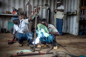 NUAC har omkring 12 ugandiske ansatte til at arbejde på gården. I dag reparerer de maskiner i værkstedet. Foto: Anders Rye Skjoldjensen. 