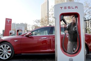 En ansat gør en Tesla Model S klar til at lade i den kinesiske by Xi'an. Hvis Kina beslutter, at der fremover kun må sælges elbiler, kan det få dramatiske konsekvenser, da det kinesiske bilmarked er verdens største. Foto: AP