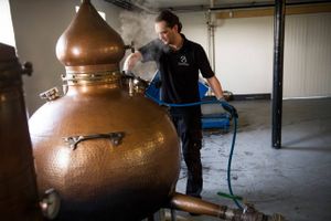 Stauning Whisky har fået høj fart i salget af whisky. Her er det Kasper Graakjær, som rengør kobberkedlerne, så de er klar til morgendagens produktion. Foto: Gregers Tycho.