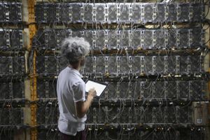 A worker inspects Bitcoin mining machines at a Canada Computational Unlimited computation center in Joliette, Quebec, Canada, on Sept. 10, 2021. Foto: Bloomberg photo by Christinne Muschi