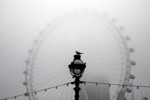 Morgentågen ligger tungt over London Eye. I baggrunden kan man lige skimte Shell Centre, olieselskabets globale hovedkvarter. Foto: Reuters/Stefan Wermuth