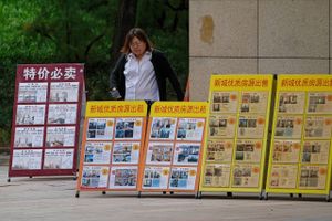 En række skilte med boliger ved et salgskontor i Beijing. Foto: Andy Wong/AP/Ritzau Scanpix
