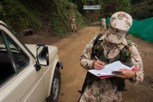 A Colombian government soldier guarding the camp for ex-guerrillas registers a driver's identification. Bloomberg photo by Nicolas Bedoya.