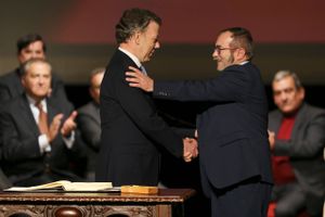 Colombias præsident, Nobel-prisvinderen Juan Manuel Santos (tv) trykker næve med Farc-lederen Rodrigo Londono efter at have underskrevet en ny fredsaftale mellem parterne. Foto: Fernando Vergara/AP