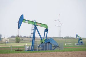 Det er ikke kun i USA, at olieproduktionen er på vej op igen. Her i Bernhardtsthal i Østrig blevoliepumperne sat i gang igen. Om strømmen leveres fra vindmøllerne i baggrunden, vides ikke.  Foto: AP/Michael Baumgartner