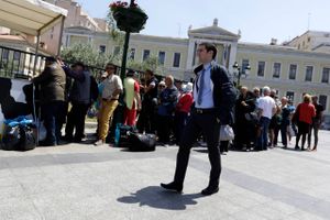 Hver dag står mange grækere i kø til uddelingen af mad foran hovedkvarteret for National Bank of Greece i hjertet af Athen. Foto: AP/Thanassis Stavrakis