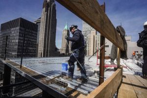     FILE - Construction workers install roofing on a high rise in Manhattan's financial district on Tuesday, April 11, 2023, in New York. For President Joe Biden, the past few days have raised hopes that the U.S. economy can stick a soft landingópossibly avoiding a recession as the 2024 election nears. Most U.S. adults have downbeat feelings about Biden's economic leadership, as high inflation has overshadowed a strong jobs market. It's long been economic orthodoxy that efforts to beat back inflation by the Federal Reserve would result in unemployment rising and the country sinking into recession. (Foto: AP Photo/Bebeto Matthews,)  