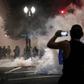 En demonstrant filmer betjente fra Trumps føderale styrke med sin telefon i Portland, Oregon. Foto: Reuters/Caitlin Ochs