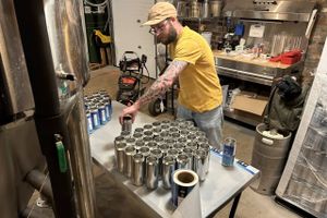 Chris Bump, the brewer at Fox City, preparing cans of Revival lager. Bloomberg photo by Ira Boudway