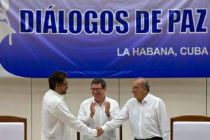 Cubas udenrigsminister klapper af fredsaftalen mellem Humberto de la Calle (th.) og FARC’s Ivan Marquez i Havana. Foto Ramon Espinosa/AP.