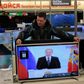 En kunde havde målebåndet fremme i tv-butikken, mens præsident Vladimir Putin holdt sin tale om nationens tilstand i Kreml. Præsidenten indledte sin tale med at tale om den »historisk vigtige genforening« tidligere på året med sortehavshalvøen Krim. Foto: Ivan Sekretarev/AP