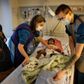 Etårige Nimco er indlagt på AUH med høj feber og mistanke om lungebetændelse. Nimcos far måtte forlade hospitalet for at få familiens andre børn i daginstitution, så moren, Fatima Aden, der ikke taler så godt dansk, får via sin mand i telefonen hjælp til at forstå, hvad sygeplejerske Stine Paaske (t.v.) siger, der skal ske. Foto: Casper Dalhoff