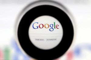 A Google search page is seen through a magnifying glass in this photo illustration taken May 30, 2014. Foto: Reuters/Francois Lenoir/File Photo  
