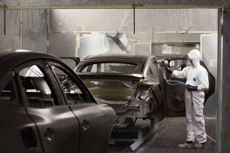 A worker sprays Renault Arkana coupe sport utility vehicle body shells in the paint shop inside the Renault SA automobile plant in Moscow. Foto: Bloomberg/Andrey Rudakov