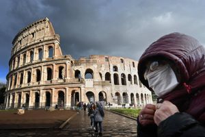     TOPSHOT - A man wearing a protective mask passes by the Coliseum in Rome on March 7, 2020 amid fear of Covid-19 epidemic. - Italy on March 6, 2020 reported 49 more deaths from the new coronavirus, the highest single-day toll to date, bringing the total number of fatalities over the past two weeks to 197. Foto: Alberto Pizzoli/AFP
