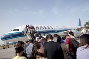 Folk står, her ved en tidligere lejlighed, i kø for at gå ombord på et fly fra China Southern Airlines, der er Kinas største målt på antallet af passagerer. Photographer: Nelson Ching/Bloomberg
  