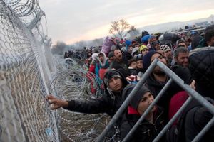 Migranter og ?ygtninge venter på at komme igennem hegnet, der skiller Grækenland og Makedonien. Udenrigsminister Kristian Jensen har inviteret en række lande til et forstærket samarbejde om at sende afviste asylsøgere hjem. Arkivfoto: Petros Giannakouris/AP