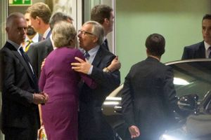 Theresa May blev mødt af kindkys fra EU-Kommissionens formand Jean-Claude Juncker, da hun mandag aften kom til middag i Bruxelles, men i britiske medier tirsdag tales der i stedet om et dødskys. Foto: AP/Virginia Mayo
