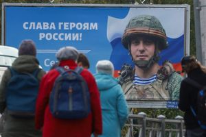 En plakat foran et busstoppested i Skt. Petersborg viser Sergej Tsjerkovnij, værnepligtig i den russiske hær, og budskabet »Æret være Ruslands helte!« Foto: Reuters/Anton Vaganov  