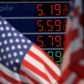 Gasoline prices are displayed at an Exxon gas station behind American flag in Edgewater, New Jersey, U.S., June 14, 2022. REUTERS/Mike Segar