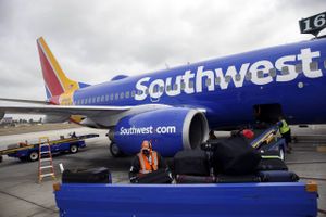 A ground operations employee loads baggage onto a Southwest Airlines Boeing 737 on the tarmac at John Wayne Airport (SNA) in Santa Ana, California, on April 14, 2016. Photo: Patrick T. Fallon/Bloomberg