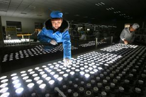 En arbejder tester LED-pærer for fejl ved en fabrik i Sichuan-provinsen. Kina kaster alt ind i tech-kapløbet - men ikke alle kneb er lige fine, siger kritikere. Chinatopix via AP