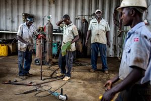 Danske flag pryder arbejdsuniformerne i det nordlige Uganda, hvor danske investorer har oprettet et landbrug og en maskinstation, nøjagtigt som de er blevet anbefalet til af deres erhvervsorganisation. Men de har mødt store udfordringer med korruption. Det skal den danske regering gøre mere for at bekæmpe, mener Mellemfolkeligt Samvirkes seniorrådgiver i ansvarlig virksomhedsadfærd. Foto: Anders Rye Skjoldjensen. 